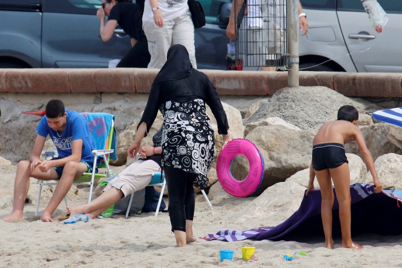 French PM defends burkini ban but some in cabinet wary